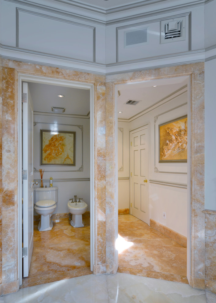 ニューヨークにある巨大なトラディショナルスタイルのおしゃれなマスターバスルーム (アンダーカウンター洗面器、家具調キャビネット、ベージュのキャビネット、オニキスの洗面台、ドロップイン型浴槽、ビデ、ベージュのタイル、石スラブタイル、大理石の床) の写真