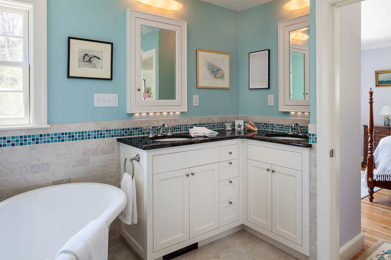 Cette image montre une salle de bain traditionnelle avec un lavabo encastré, un placard à porte affleurante, un plan de toilette en granite, une baignoire indépendante, une douche d'angle, WC séparés, un carrelage beige, des carreaux de porcelaine, un mur bleu et un sol en carrelage de céramique.