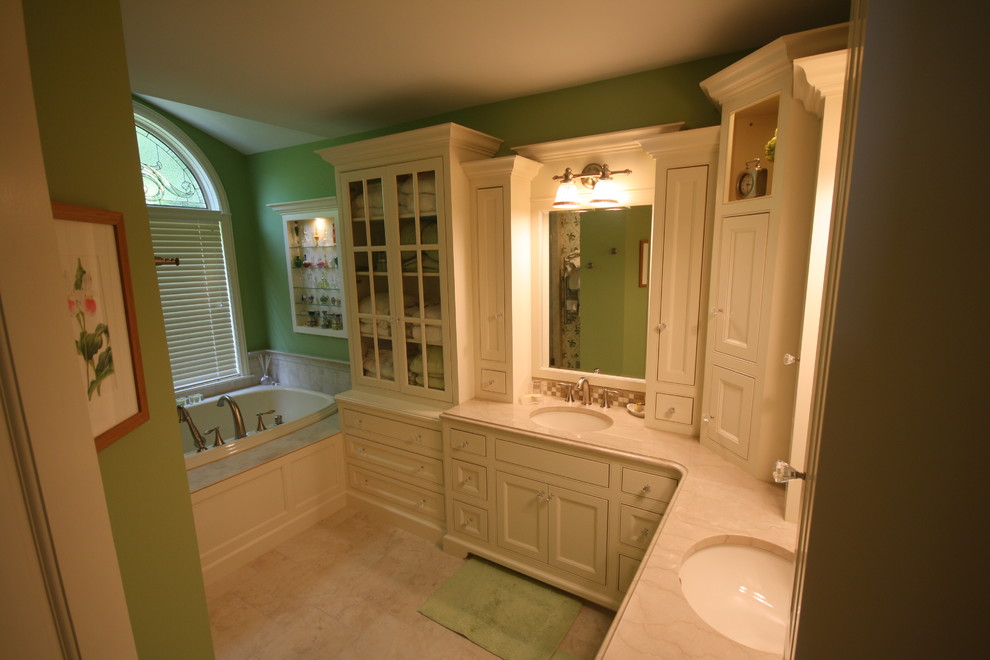 Idées déco pour une salle de bain principale classique de taille moyenne avec un placard à porte affleurante, des portes de placard blanches, une baignoire en alcôve, un carrelage beige, un carrelage en pâte de verre, un mur vert, un sol en carrelage de céramique, un lavabo encastré, un plan de toilette en marbre et un sol beige.
