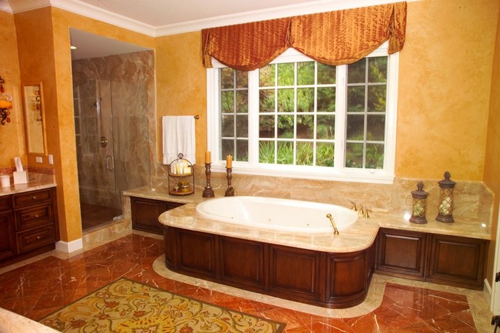 ロサンゼルスにある広いトラディショナルスタイルのおしゃれな浴室 (レイズドパネル扉のキャビネット、濃色木目調キャビネット、ベージュの壁、オーバーカウンターシンク) の写真