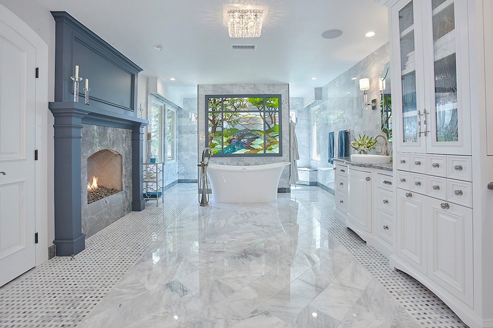 Idées déco pour une grande salle de bain principale contemporaine avec un placard avec porte à panneau surélevé, des portes de placard blanches, une baignoire indépendante, un mur gris, un sol en marbre, une vasque, un plan de toilette en granite et un sol gris.