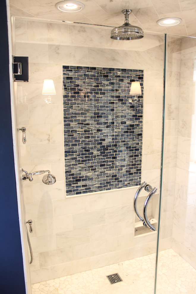 Alcove shower - small coastal master beige tile and pebble tile ceramic tile alcove shower idea in New York with furniture-like cabinets, white cabinets, a one-piece toilet, blue walls, a drop-in sink and marble countertops