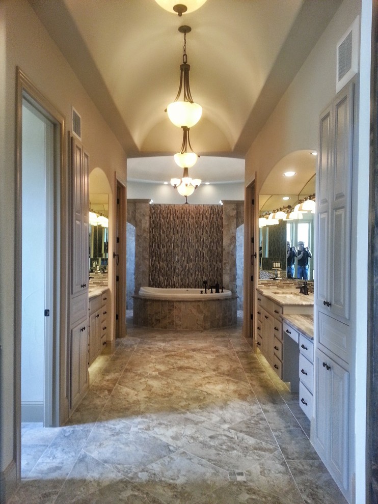 Large classic ensuite bathroom in Austin with raised-panel cabinets, white cabinets, a built-in bath, white walls, porcelain flooring, a submerged sink, marble worktops, multi-coloured tiles, mosaic tiles and grey floors.