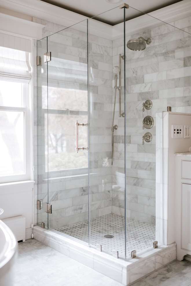 This is an example of a classic ensuite bathroom in Minneapolis with beaded cabinets, white cabinets, a freestanding bath, a corner shower, white walls, marble flooring, a submerged sink, marble worktops, a hinged door and white worktops.