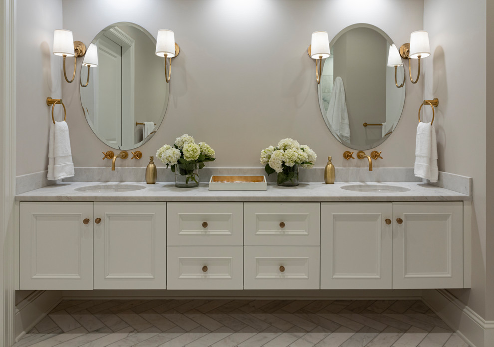 Cette photo montre une grande salle de bain principale chic avec un placard avec porte à panneau encastré, des portes de placard blanches, une douche à l'italienne, un mur gris, un sol en carrelage de porcelaine, un lavabo encastré, un plan de toilette en quartz, un sol gris, une cabine de douche à porte battante et un plan de toilette gris.