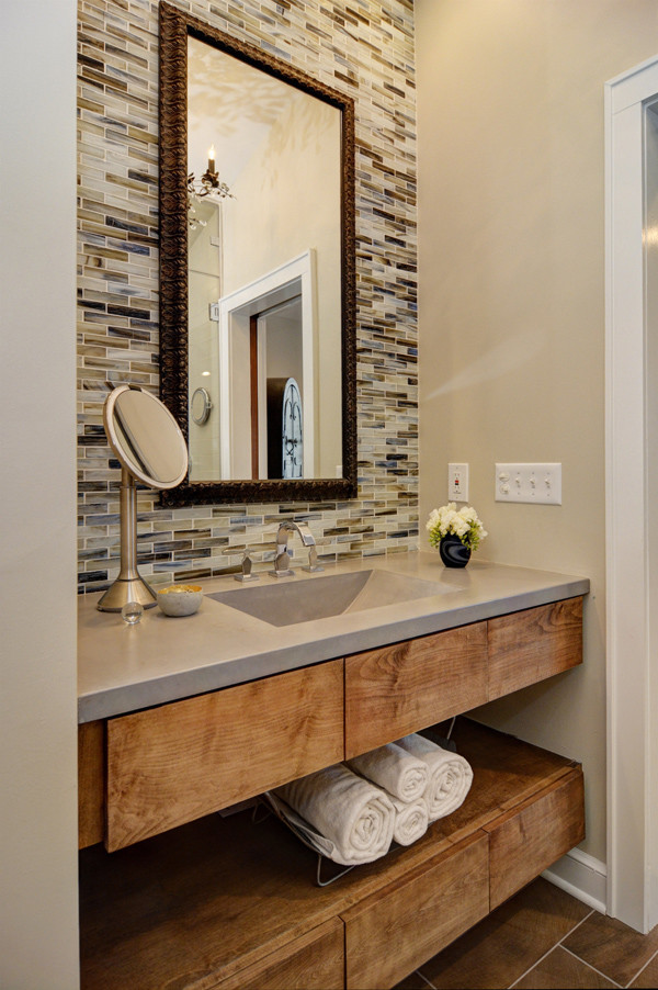 Immagine di una stanza da bagno padronale minimal di medie dimensioni con ante lisce, piastrelle marroni, pareti beige, ante in legno chiaro, piastrelle di vetro, lavabo integrato e top in cemento