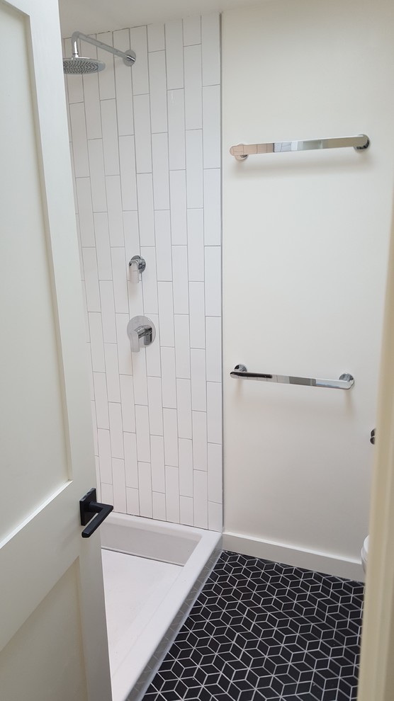 Ejemplo de cuarto de baño principal contemporáneo de tamaño medio con ducha empotrada, baldosas y/o azulejos blancos, baldosas y/o azulejos de cemento, paredes blancas, suelo de baldosas de porcelana, suelo negro y ducha abierta
