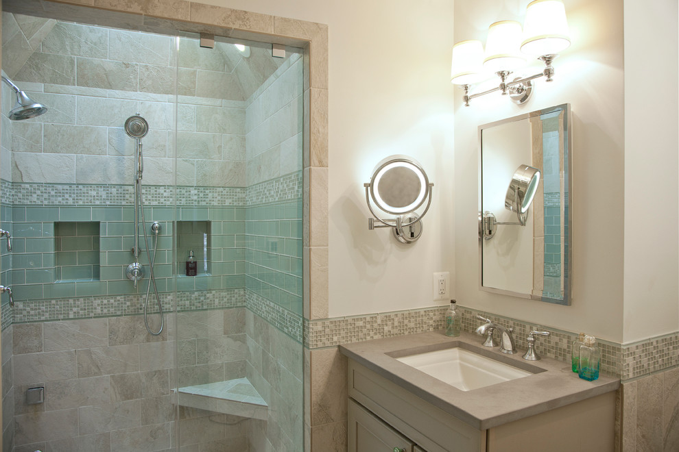 Inredning av ett klassiskt mellanstort badrum med dusch, med ett undermonterad handfat, luckor med infälld panel, bänkskiva i kvarts, en dusch i en alkov, en toalettstol med separat cisternkåpa, grå kakel, glaskakel, vita väggar, klinkergolv i porslin, beiget golv, dusch med gångjärnsdörr och grå skåp