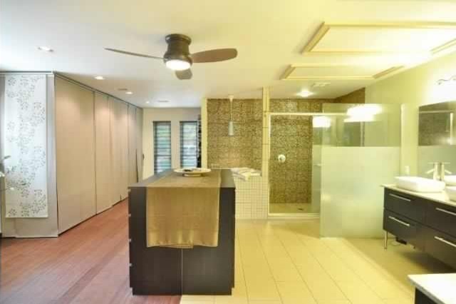 Modern inredning av ett mycket stort en-suite badrum, med möbel-liknande, skåp i mörkt trä, ett japanskt badkar, en öppen dusch, en toalettstol med separat cisternkåpa, brun kakel, glasskiva, gröna väggar, klinkergolv i porslin, ett fristående handfat och bänkskiva i kvarts