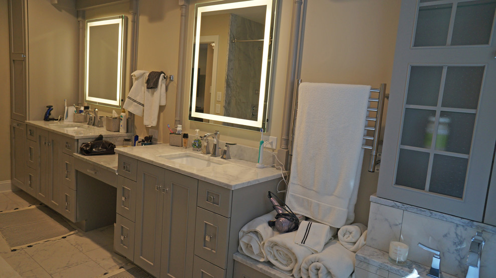 Inspiration för stora moderna en-suite badrum, med ett undermonterad handfat, släta luckor, grå skåp, marmorbänkskiva, ett fristående badkar, en dusch i en alkov, en toalettstol med separat cisternkåpa, vit kakel, porslinskakel, beige väggar och klinkergolv i porslin