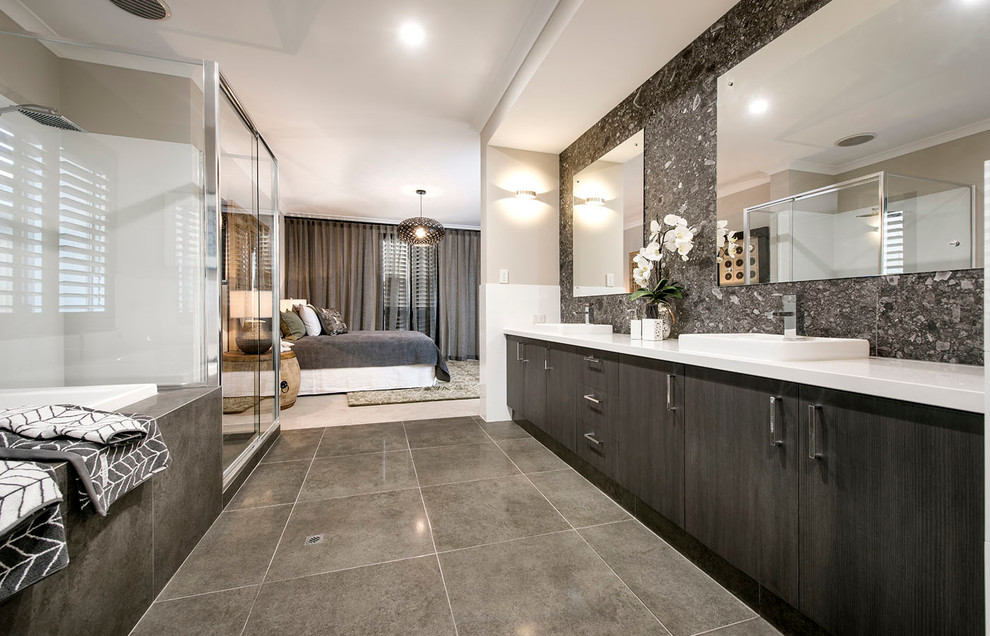 Inspiration for a large contemporary ensuite bathroom in Perth with a built-in sink, flat-panel cabinets, dark wood cabinets, engineered stone worktops, a built-in bath, a walk-in shower, a one-piece toilet, grey tiles, porcelain tiles, beige walls and porcelain flooring.