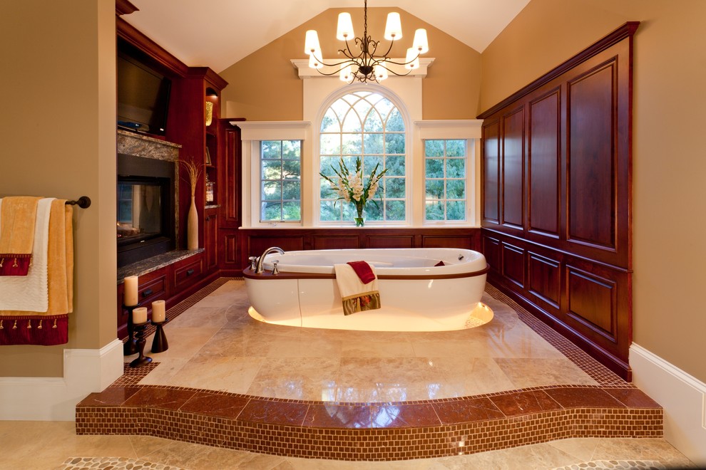 Foto di una stanza da bagno padronale tradizionale con ante con bugna sagomata, ante in legno bruno, vasca freestanding, piastrelle beige e pareti beige