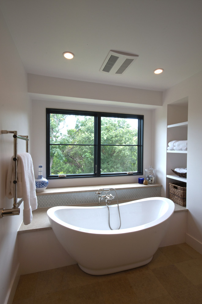 Esempio di una stanza da bagno padronale contemporanea di medie dimensioni con ante lisce, ante bianche, vasca freestanding, piastrelle grigie, piastrelle di vetro, pareti bianche e pavimento in pietra calcarea