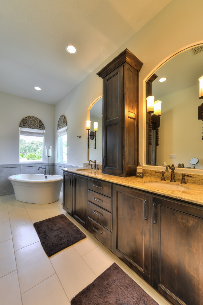 Example of a large tuscan master gray tile and ceramic tile ceramic tile bathroom design in Austin with a drop-in sink, shaker cabinets, medium tone wood cabinets, granite countertops and beige walls