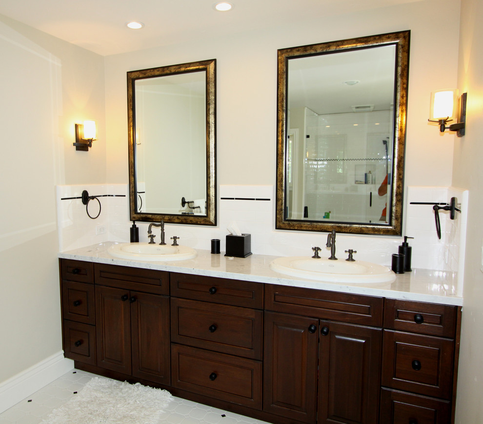 На фото: ванная комната в классическом стиле с накладной раковиной, фасадами с выступающей филенкой, темными деревянными фасадами и белой плиткой