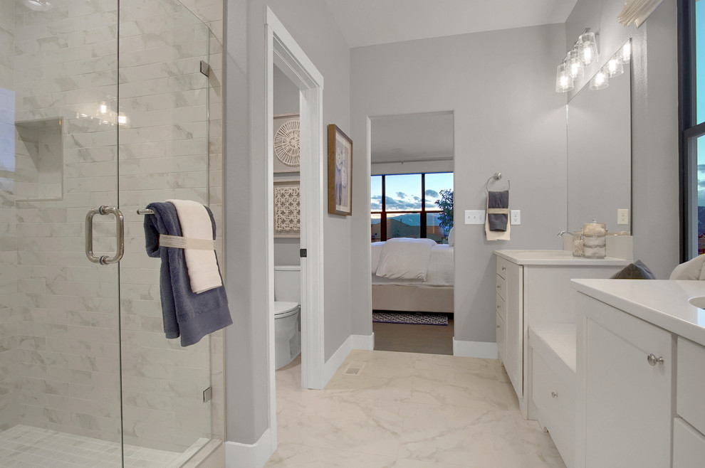 Design ideas for a medium sized country ensuite bathroom in Denver with recessed-panel cabinets, grey cabinets, an alcove shower, a two-piece toilet, white tiles, porcelain tiles, grey walls, porcelain flooring, a submerged sink, engineered stone worktops, white floors, a hinged door and white worktops.