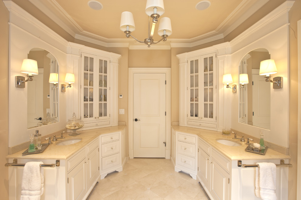 Inredning av ett klassiskt en-suite badrum, med ett fristående badkar, en dusch i en alkov, en toalettstol med hel cisternkåpa, vita skåp, bänkskiva i onyx, marmorgolv och luckor med upphöjd panel
