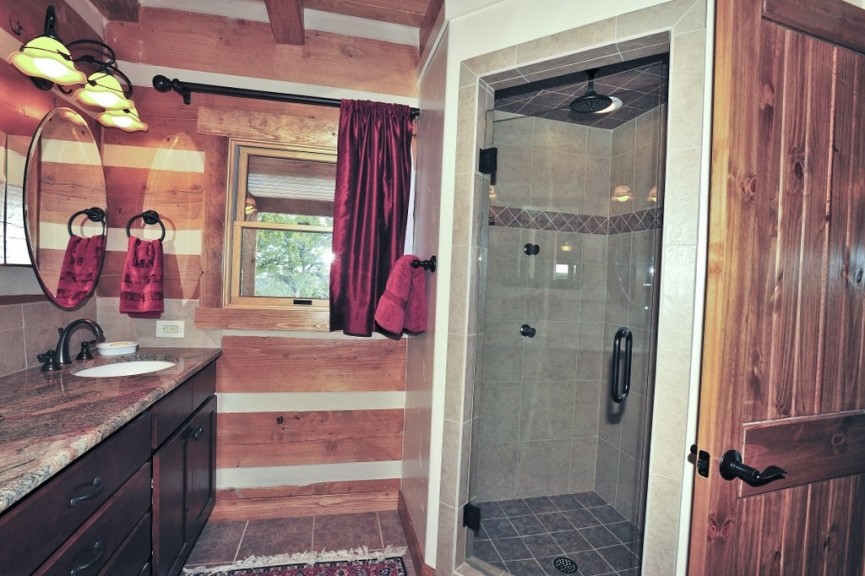 Immagine di una stanza da bagno padronale stile rurale con lavabo da incasso, ante in stile shaker, ante in legno bruno, top in granito, doccia ad angolo, piastrelle beige, piastrelle in pietra e pavimento in ardesia
