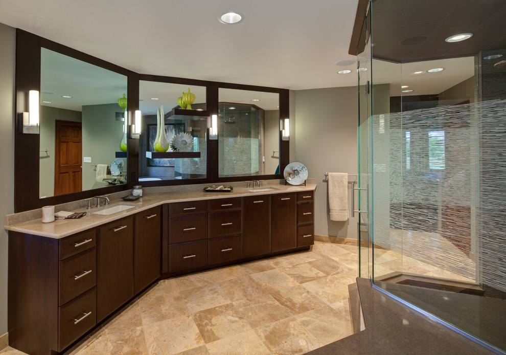 Design ideas for a large traditional ensuite bathroom in Chicago with a submerged sink, flat-panel cabinets, dark wood cabinets, solid surface worktops, a submerged bath, beige tiles, stone tiles, grey walls and travertine flooring.