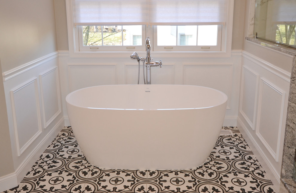 Пример оригинального дизайна: большая главная ванная комната в стиле неоклассика (современная классика) с фасадами с выступающей филенкой, белыми фасадами, отдельно стоящей ванной, угловым душем, унитазом-моноблоком, черно-белой плиткой, мраморной плиткой, серыми стенами, полом из керамической плитки, врезной раковиной, столешницей из гранита, разноцветным полом, душем с распашными дверями, разноцветной столешницей, сиденьем для душа, тумбой под две раковины, встроенной тумбой, сводчатым потолком и панелями на стенах