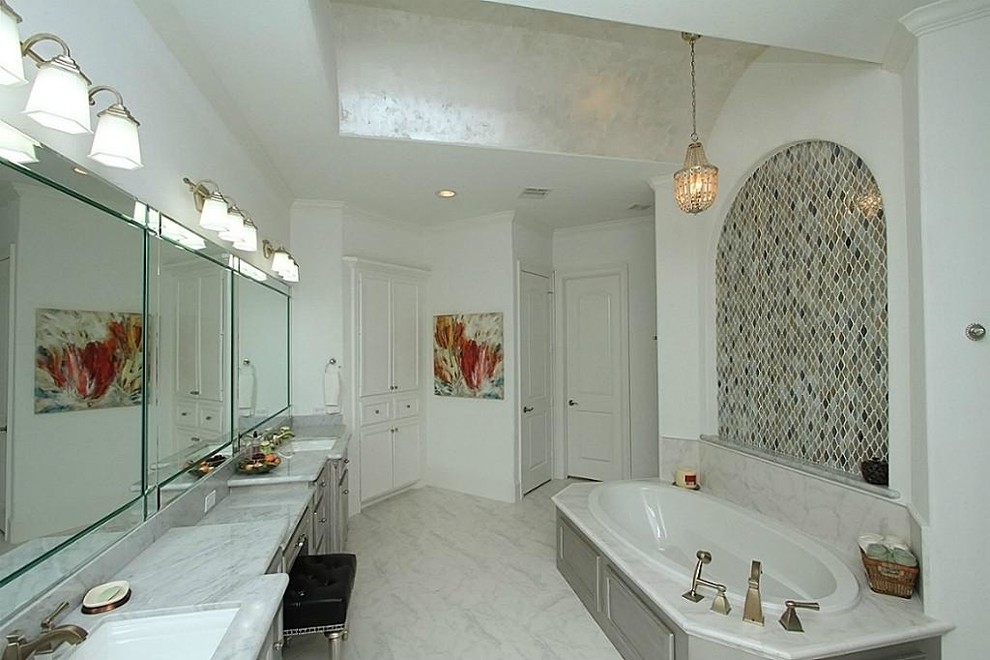 Photo of a large classic ensuite bathroom in Houston with a submerged sink, raised-panel cabinets, marble worktops, a built-in bath, multi-coloured tiles, white walls, an alcove shower, a two-piece toilet, porcelain flooring, grey cabinets and mosaic tiles.