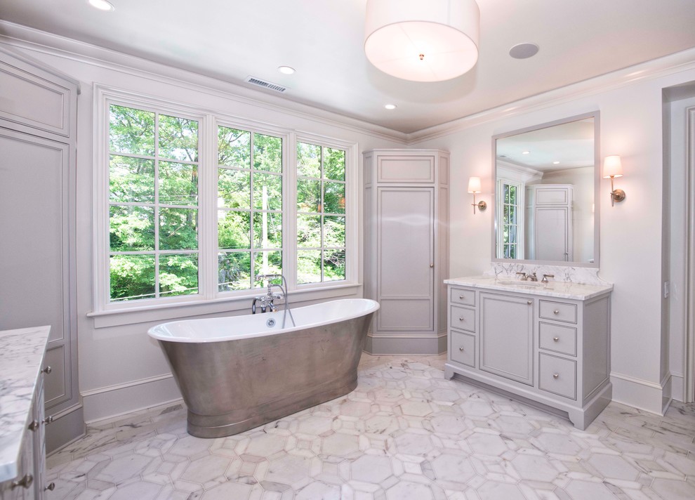 Freestanding bathtub - large traditional master white tile and stone tile marble floor freestanding bathtub idea in New York with beaded inset cabinets, white cabinets, white walls, marble countertops and an undermount sink