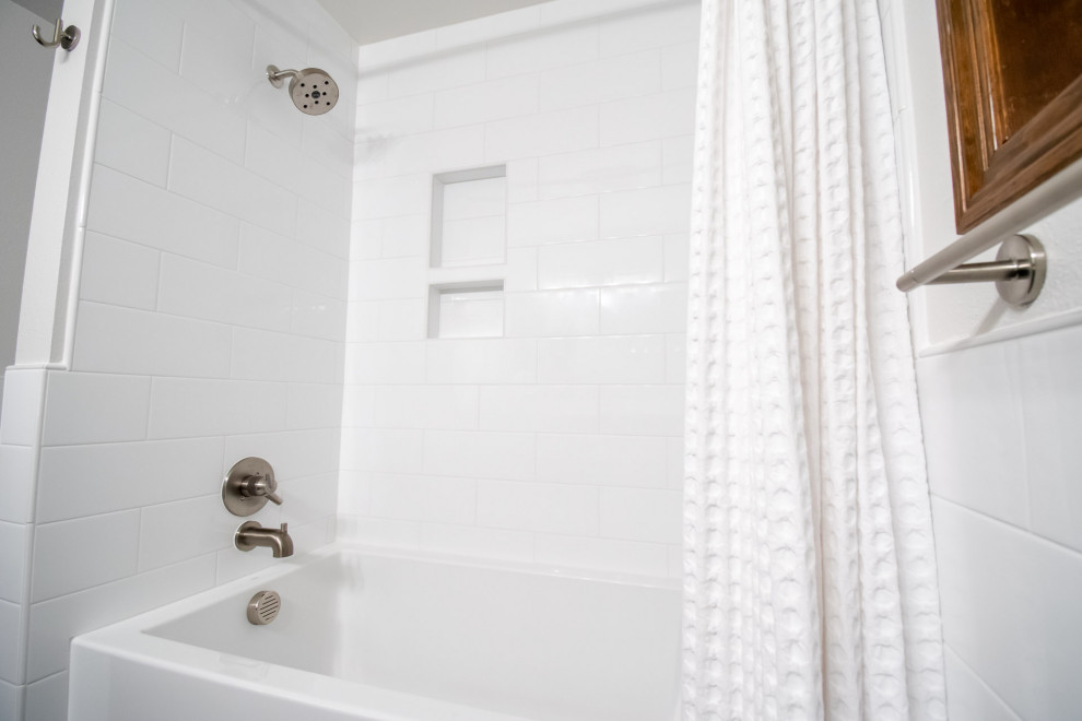 Exempel på ett litet modernt vit vitt badrum för barn, med släta luckor, skåp i mellenmörkt trä, ett badkar i en alkov, en dusch/badkar-kombination, en toalettstol med separat cisternkåpa, vit kakel, keramikplattor, vita väggar, klinkergolv i keramik, ett undermonterad handfat, bänkskiva i kvarts, svart golv och dusch med duschdraperi