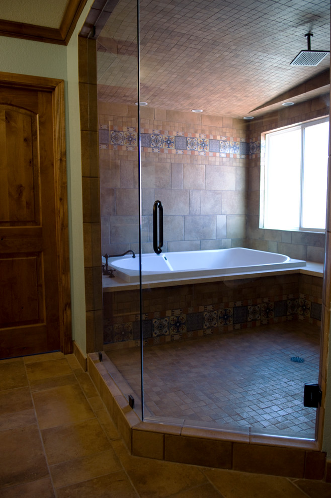 Exempel på ett stort medelhavsstil en-suite badrum, med luckor med profilerade fronter, skåp i mellenmörkt trä, ett platsbyggt badkar, en öppen dusch, flerfärgad kakel, cementkakel, blå väggar, klinkergolv i terrakotta, ett undermonterad handfat och bänkskiva i kalksten