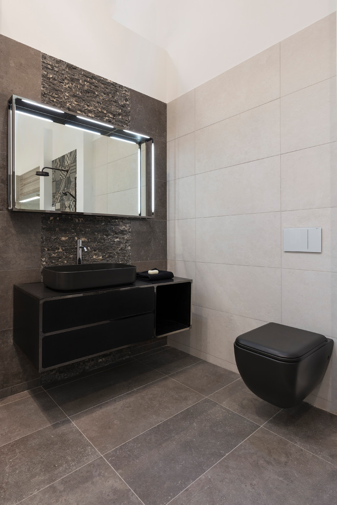 Idéer för att renovera ett funkis badrum, med släta luckor, svarta skåp, en vägghängd toalettstol, grå väggar, ett fristående handfat och grått golv