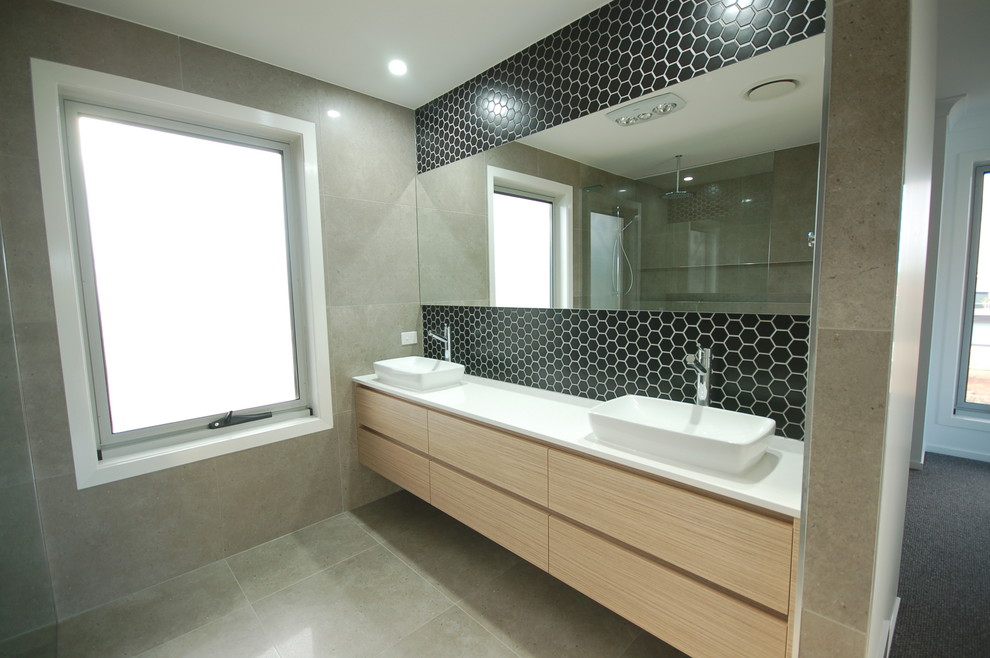 Diseño de cuarto de baño moderno con baldosas y/o azulejos negros, baldosas y/o azulejos en mosaico y suelo con mosaicos de baldosas