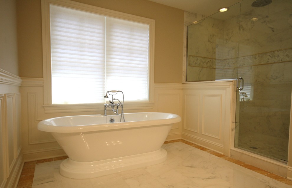 Aménagement d'une grande salle de bain principale classique avec une baignoire indépendante, une douche d'angle, un carrelage gris, du carrelage en marbre, un mur beige, un sol en marbre, un sol gris et une cabine de douche à porte battante.
