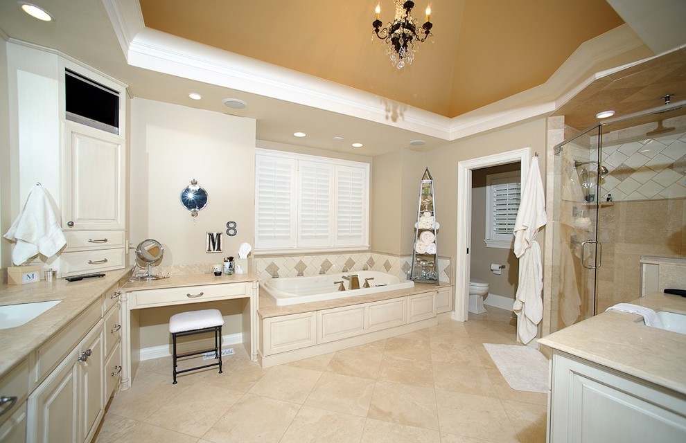 На фото: ванная комната в классическом стиле с врезной раковиной, фасадами с выступающей филенкой, белыми фасадами, накладной ванной, душем в нише и бежевой плиткой с
