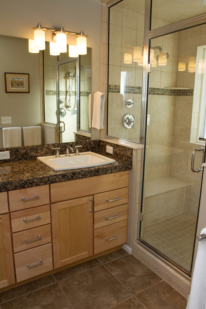 Inspiration for a mid-sized timeless 3/4 beige tile and ceramic tile ceramic tile and brown floor alcove shower remodel in Denver with recessed-panel cabinets, light wood cabinets, beige walls, a drop-in sink, quartz countertops and a hinged shower door