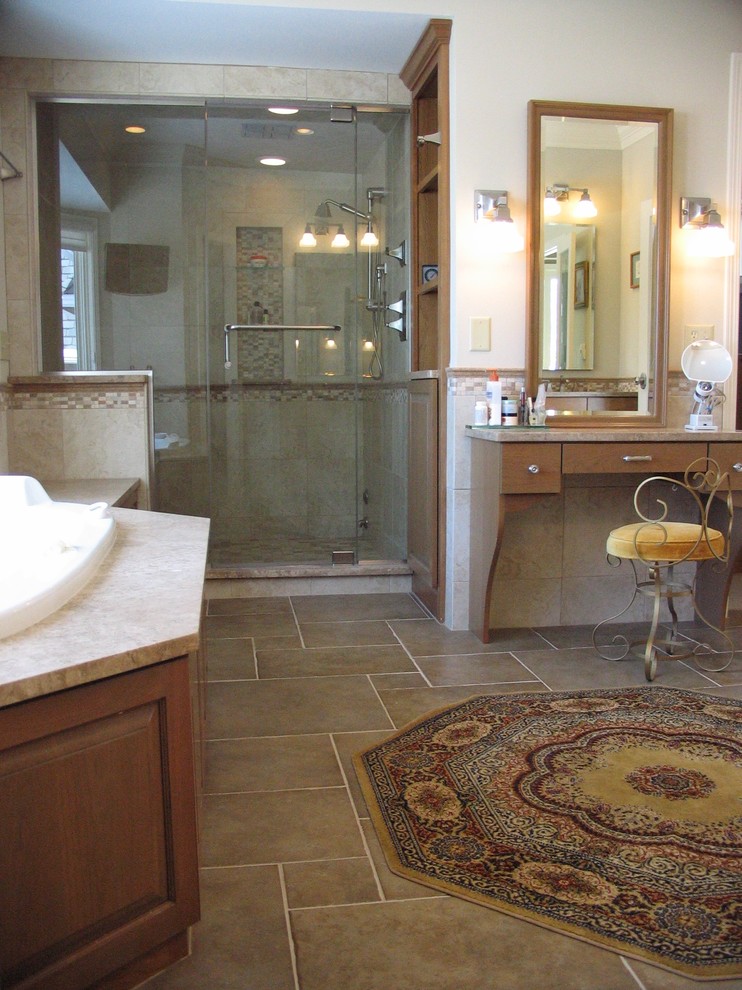 Mid-sized elegant master brown tile and stone tile travertine floor bathroom photo in Minneapolis with an undermount sink, raised-panel cabinets, medium tone wood cabinets, a two-piece toilet and beige walls