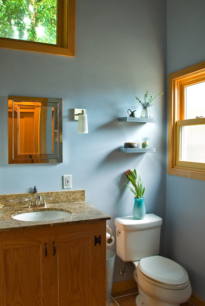 Idée de décoration pour une petite salle de bain principale chalet en bois brun avec un lavabo posé, un placard avec porte à panneau encastré, un plan de toilette en granite, une baignoire en alcôve, un combiné douche/baignoire, WC séparés, un mur bleu et tomettes au sol.