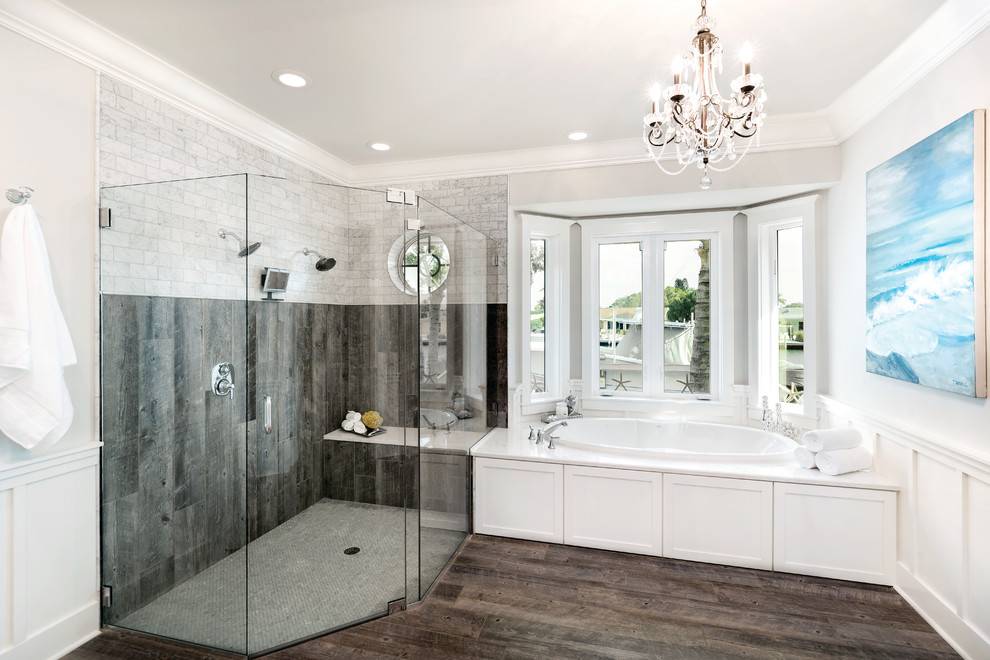 На фото: главная ванная комната в стиле неоклассика (современная классика) с белыми фасадами, ванной в нише и угловым душем