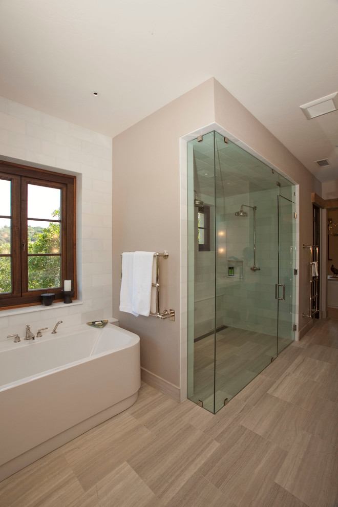 Ejemplo de cuarto de baño principal contemporáneo de tamaño medio con bañera exenta, ducha empotrada, sanitario de dos piezas, paredes beige y suelo de madera clara