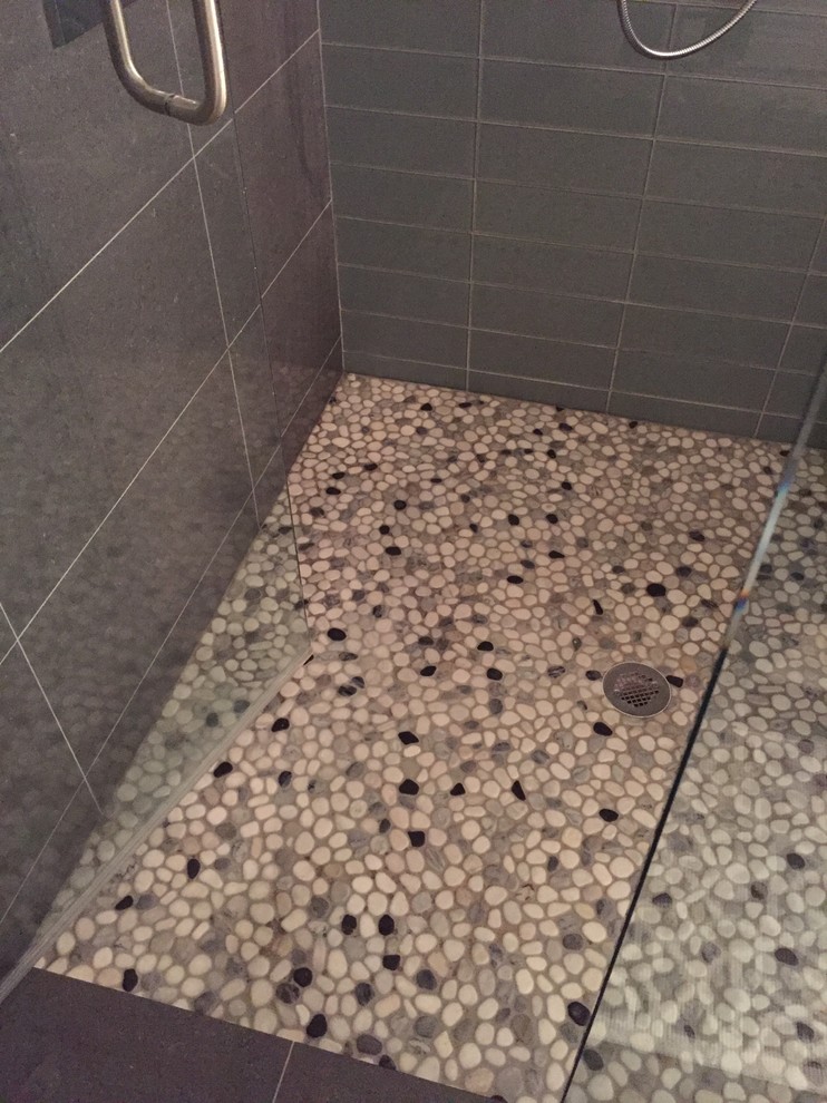 Example of a large trendy master gray tile and glass tile porcelain tile doorless shower design in Tampa with flat-panel cabinets, dark wood cabinets, a one-piece toilet, blue walls, a vessel sink and recycled glass countertops