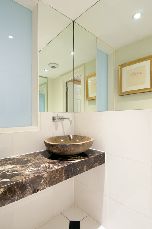 Foto de cuarto de baño único, contemporáneo, pequeño, con sanitario de pared, baldosas y/o azulejos blancos, baldosas y/o azulejos de cerámica, paredes blancas, suelo de baldosas de cerámica, lavabo sobreencimera, encimera de mármol, suelo multicolor y encimeras marrones