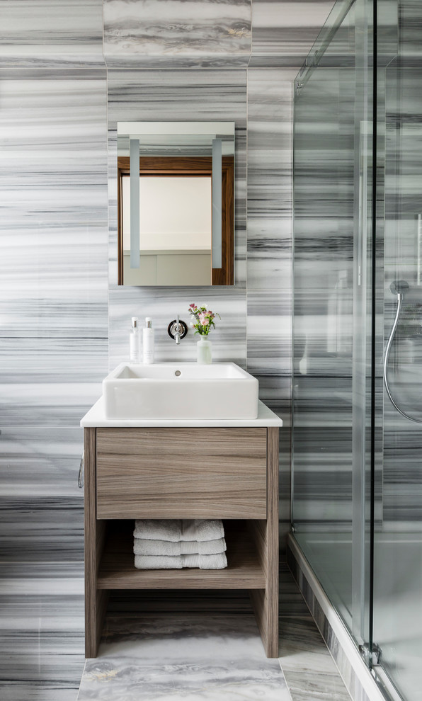 Inredning av ett modernt badrum, med släta luckor, skåp i ljust trä, svart och vit kakel, grå kakel, flerfärgade väggar, ett fristående handfat och dusch med skjutdörr