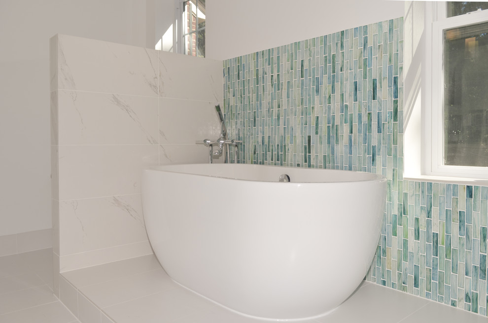 На фото: главная ванная комната среднего размера в стиле модернизм с накладной раковиной, плоскими фасадами, белыми фасадами, столешницей из искусственного кварца, отдельно стоящей ванной, угловым душем, унитазом-моноблоком, синей плиткой, стеклянной плиткой, белыми стенами и полом из керамической плитки