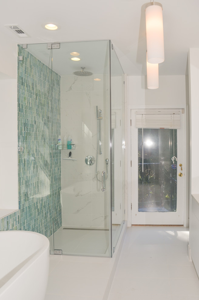 Inspiration for a medium sized modern ensuite bathroom in DC Metro with a built-in sink, flat-panel cabinets, white cabinets, engineered stone worktops, a freestanding bath, a corner shower, a one-piece toilet, blue tiles, glass tiles, white walls and ceramic flooring.