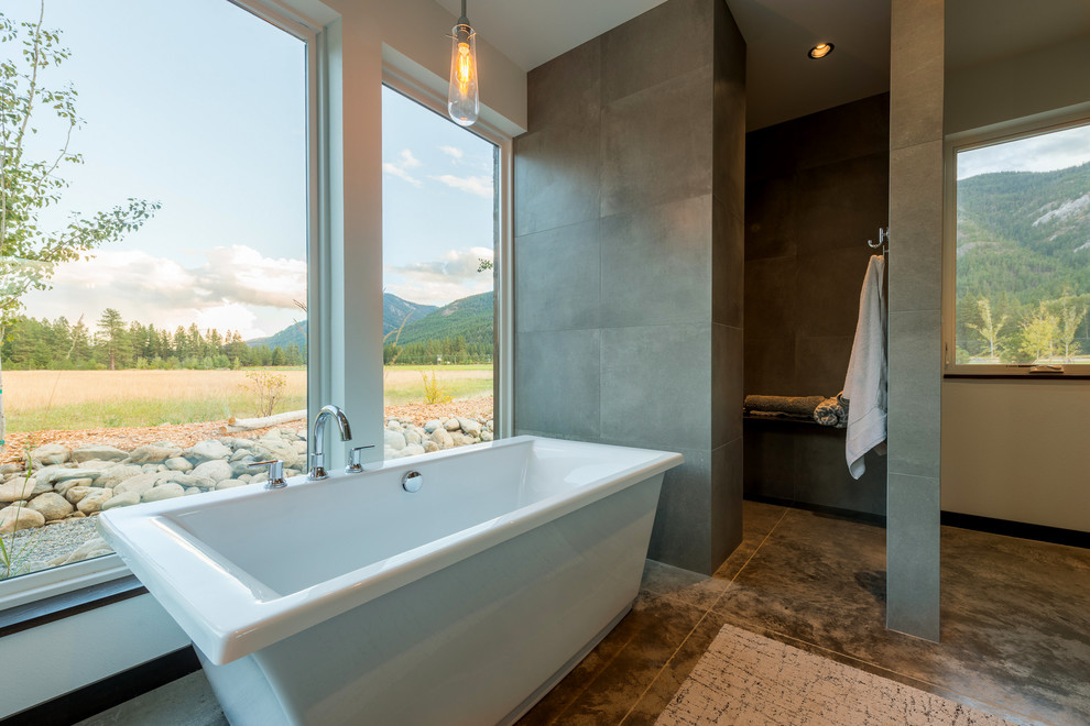 This is an example of a large modern bathroom in Seattle with a freestanding bath, an alcove shower, concrete flooring, beige floors and an open shower.