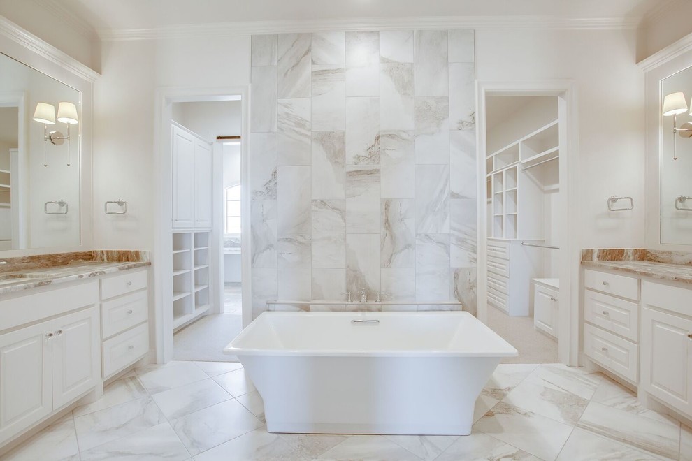 Cette photo montre une grande salle de bain principale chic avec un placard avec porte à panneau surélevé, des portes de placard blanches, une baignoire indépendante, un carrelage blanc, du carrelage en marbre, un mur blanc, un sol en marbre, un lavabo encastré et un sol blanc.