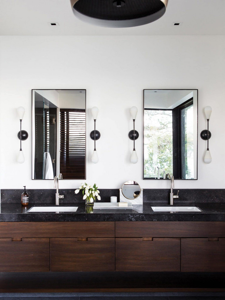 Esempio di una stanza da bagno minimal con ante lisce, ante in legno bruno, pareti bianche, lavabo sottopiano, pavimento grigio, top nero, due lavabi e mobile bagno sospeso