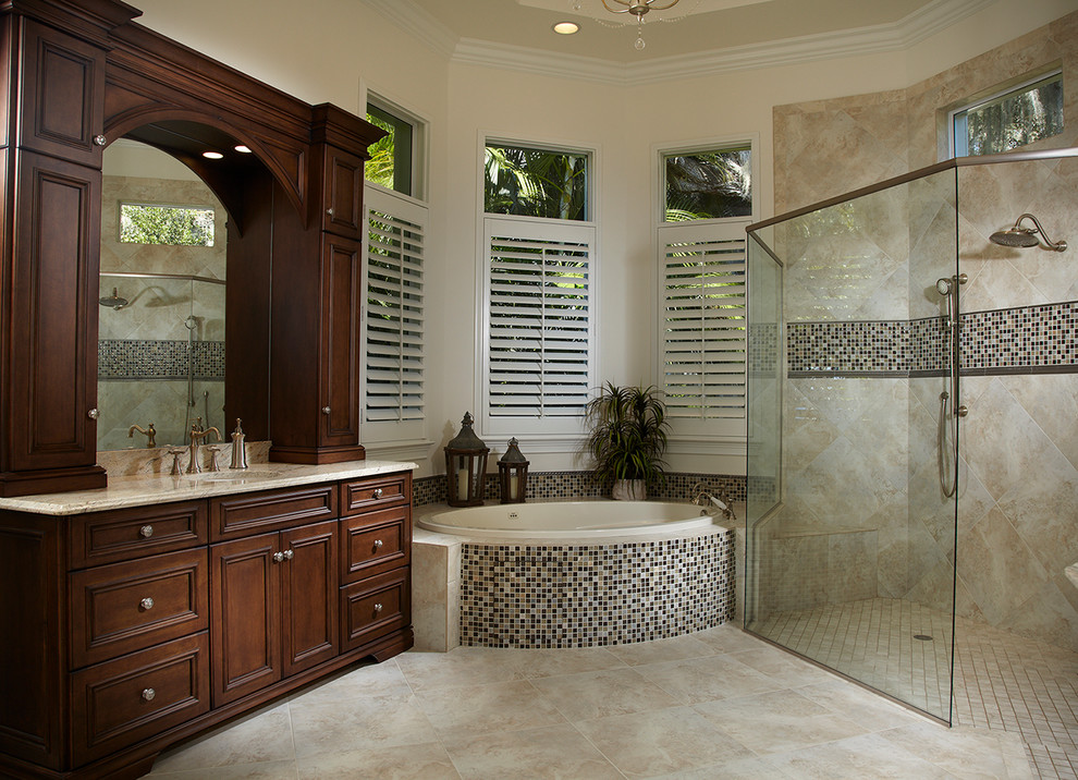 Idee per una stanza da bagno classica con lavabo sottopiano, ante con riquadro incassato, ante in legno bruno, vasca da incasso, piastrelle beige, pareti beige e pavimento beige