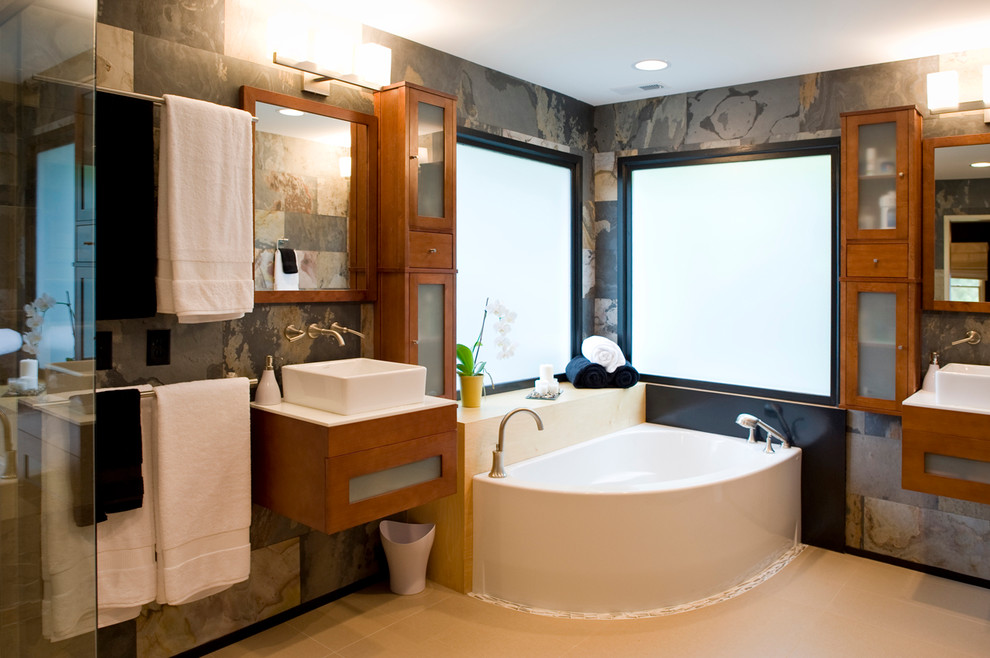 Example of a large asian master porcelain tile porcelain tile and beige floor bathroom design in Raleigh with flat-panel cabinets, medium tone wood cabinets, gray walls, a vessel sink and a hinged shower door