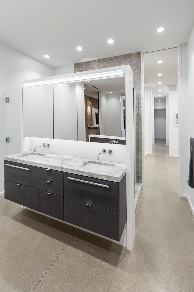 Large urban ensuite bathroom in Cincinnati with flat-panel cabinets, white cabinets, a freestanding bath, a walk-in shower, white tiles, porcelain tiles, white walls, concrete flooring, a submerged sink, grey floors and an open shower.