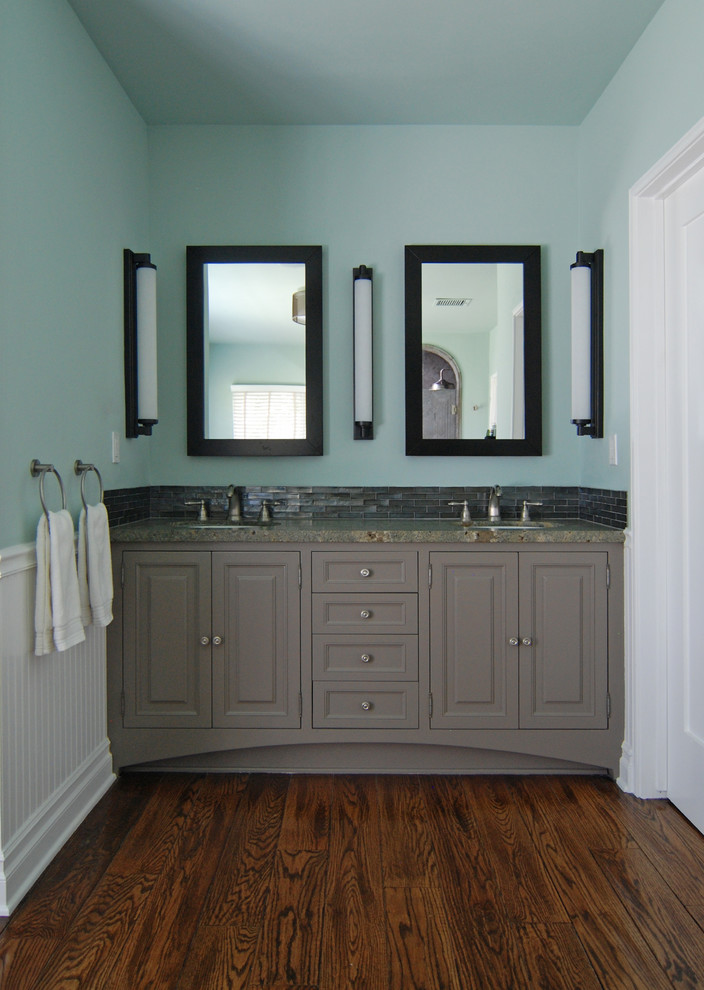 Ejemplo de cuarto de baño tradicional renovado con lavabo bajoencimera, armarios con paneles con relieve, puertas de armario grises, bañera con patas y baldosas y/o azulejos grises