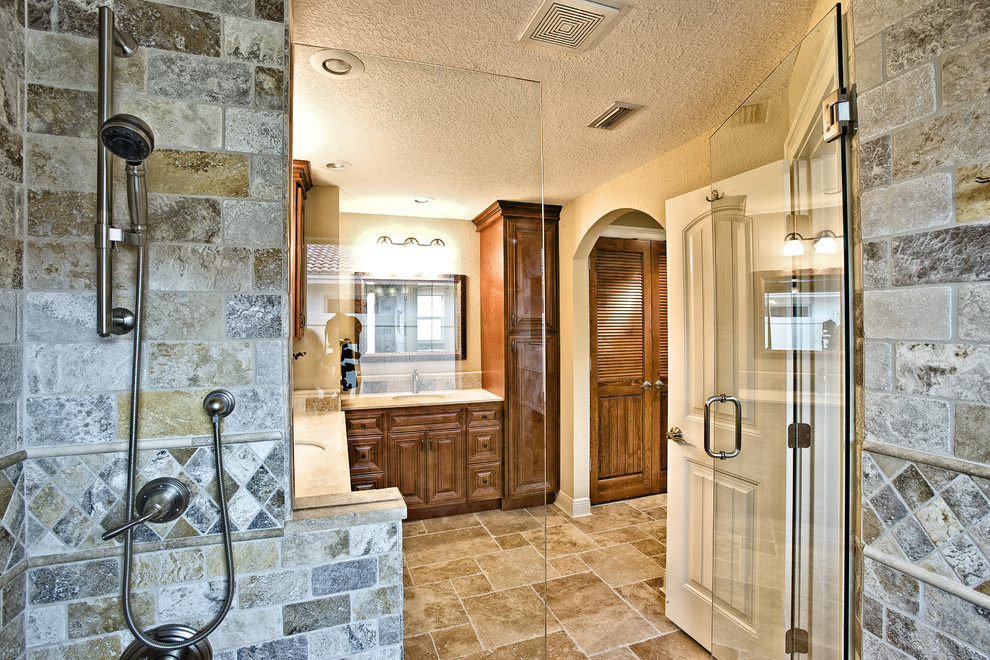 Cette photo montre une grande douche en alcôve principale éclectique en bois brun avec un placard avec porte à panneau surélevé, un carrelage beige, un carrelage marron, un carrelage de pierre, un mur beige, un sol en travertin et un lavabo encastré.